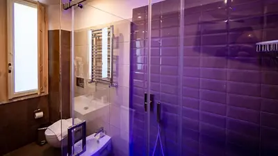 a bathroom with a glass shower with a toilet at Borghese Executive Suite in Rome