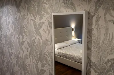 a small bedroom with a bed in a room with wallpaper at Borghese Executive Suite in Rome