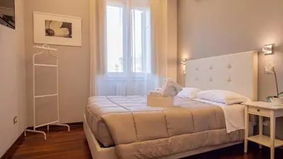 a bedroom with a white bed and a window at Borghese Executive Suite in Rome