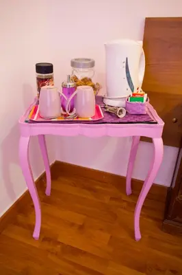 a pink table with cups and other items on it at Laterano Inn in Rome