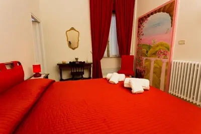 a bedroom with a red bed with towels on it at Laterano Inn in Rome