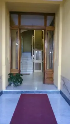 an entrance to a building with a red rug in front at Laterano Inn in Rome