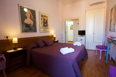 a bedroom with a purple bed with two towels on it at Laterano Inn in Rome
