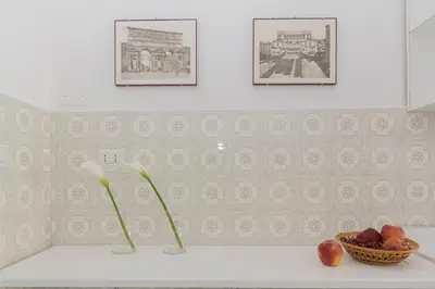 a kitchen counter with two vases and a bowl of fruit at Ad Astra Suite in Rome