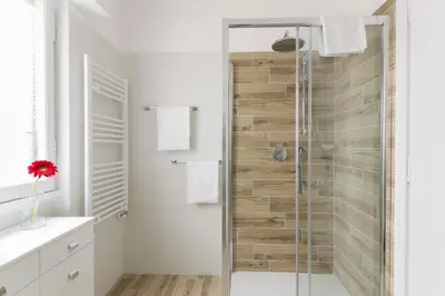 a bathroom with a shower with a glass door at Ad Astra Suite in Rome