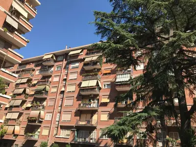 an apartment building with balconies and a tree at Ad Astra Suite in Rome