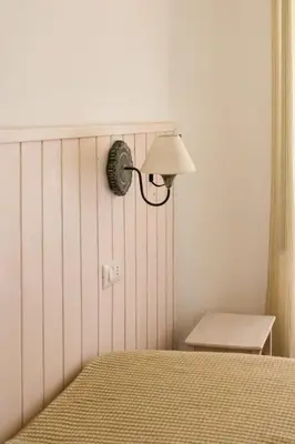 a lamp on a wall next to a bed at Residenza I Rioni Guesthouse in Rome