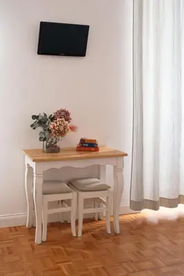 a white table with a vase of flowers on it at Residenza I Rioni Guesthouse in Rome
