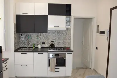 a kitchen with white cabinets and a stove at Apartment Silvestri in Rome