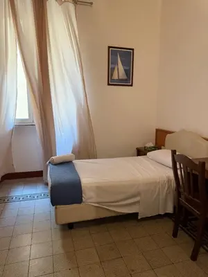 a brown leather couch sitting in a room with a clock at Soggiorno Emanuela in Rome