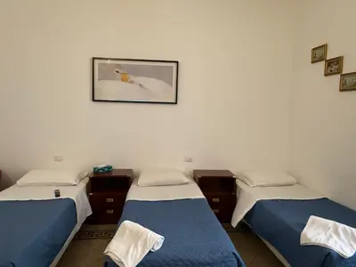 a hotel room with two beds and a flat screen tv at Soggiorno Emanuela in Rome
