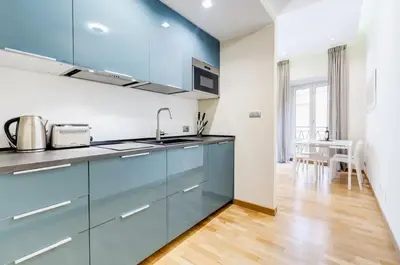 a kitchen with blue cabinets and a wooden floor at ELICAL Luxury Apartments in Rome