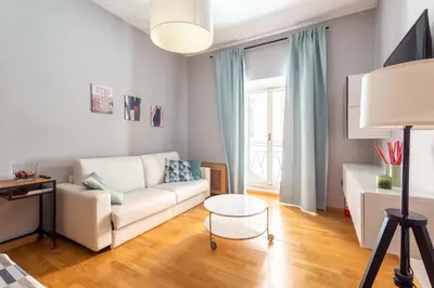 a living room with a white couch and a table at ELICAL Luxury Apartments in Rome