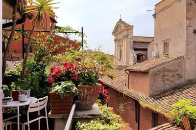a balcony with a table and flowers on a building at Scala Luxury Terrace studio in Rome