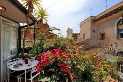 a balcony with a table and flowers on a building at Scala Luxury Terrace studio in Rome