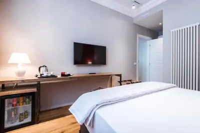 a bedroom with a bed and a tv on the wall at Giselda Home in Rome