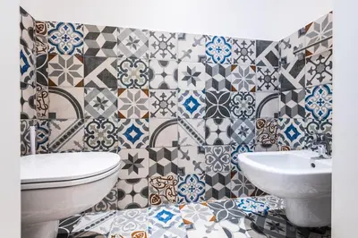a bathroom with a toilet and a sink and tiles at Giselda Home in Rome