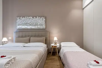a bedroom with two beds and a painting on the wall at St. Peter's Refuge 2 in Rome