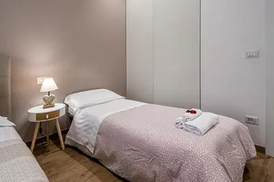 a bedroom with two beds and a table with a lamp at St. Peter's Refuge 2 in Rome