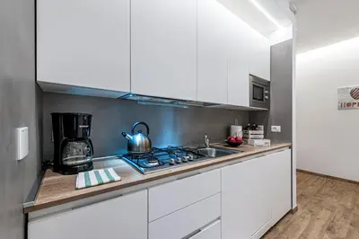 a kitchen with white cabinets and a stove top oven at St. Peter's Refuge 2 in Rome