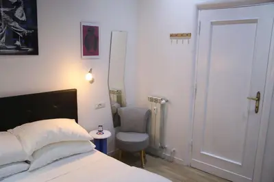 a bedroom with a bed and a chair and a door at Mila Guest House in Rome