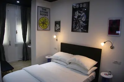 a bedroom with a bed with white sheets and pillows at Mila Guest House in Rome