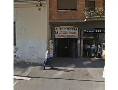 a man walking down the street in front of a store at B&B Emozioni Romane in Rome