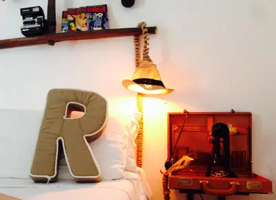 a letter k sitting on a bed next to a lamp at Jacuzzi Rooms in Rome
