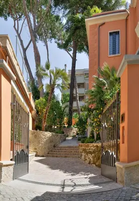 a gate to a building with stairs and palm trees at Contessa Arrivabene Antica Dimora in Rome