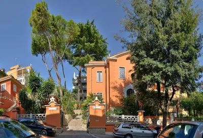 a orange house with cars parked in front of it at Contessa Arrivabene Antica Dimora in Rome
