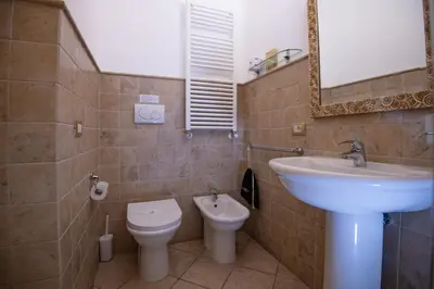 a bathroom with a sink and a toilet and a mirror at Contessa Arrivabene Antica Dimora in Rome