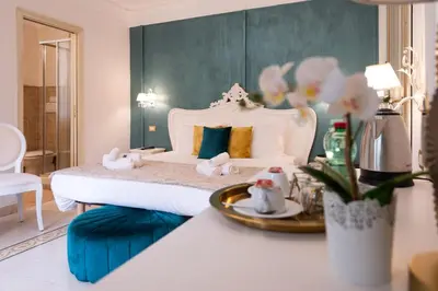 a bedroom with a white bed and a table with towels at Contessa Arrivabene Antica Dimora in Rome