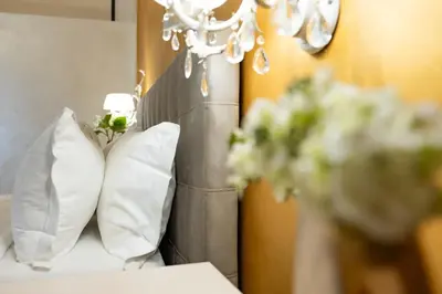 a room with a bed with pillows and a chandelier at Contessa Arrivabene Antica Dimora in Rome