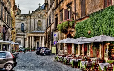 a street with tables and umbrellas in a city at Suites Roma Tiburtina Economy in Rome