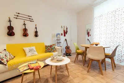 a living room with a yellow couch and a table at LA PERLA RARA Vatican Sweet Home in Rome