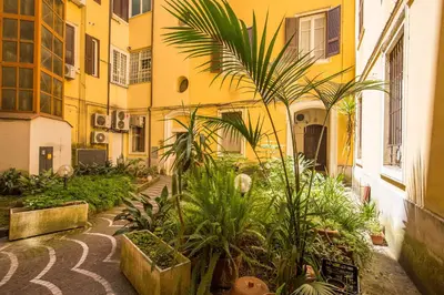 a courtyard with plants in front of a building at LA PERLA RARA Vatican Sweet Home in Rome
