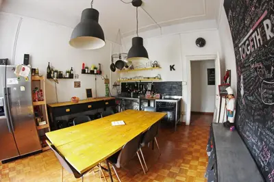 a kitchen with a wooden table and a kitchen with a refrigerator at Coliving Trastevere in Rome