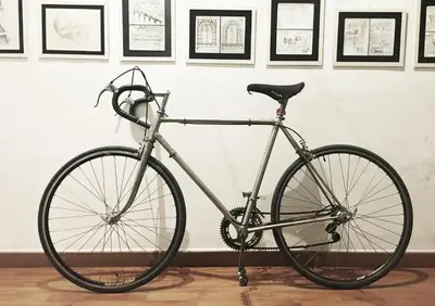 a bike parked in front of a wall with pictures at Coliving Trastevere in Rome