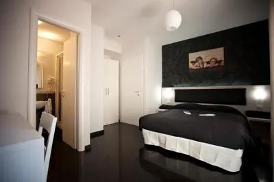 a bedroom with a black and white bed and a bathroom at Heart of Rome Rooms in Rome