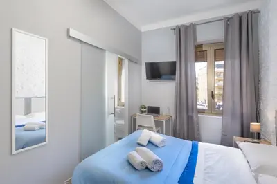a bedroom with a blue bed with two pillows at Comfort Rooms Piazza Mariano Armellini in Rome