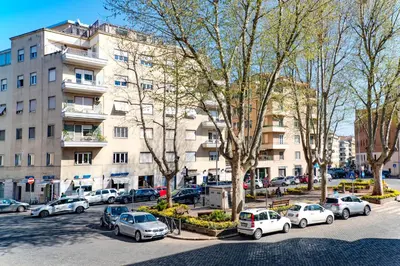 a parking lot with cars parked in front of a building at Comfort Rooms Piazza Mariano Armellini in Rome
