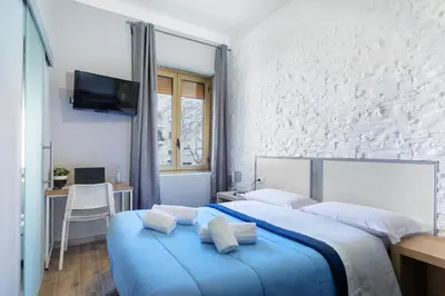 a bedroom with a large bed with blue sheets at Comfort Rooms Piazza Mariano Armellini in Rome