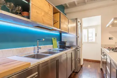 a kitchen with a sink and a blue wall at CS Spanish Steps Apartment in Rome