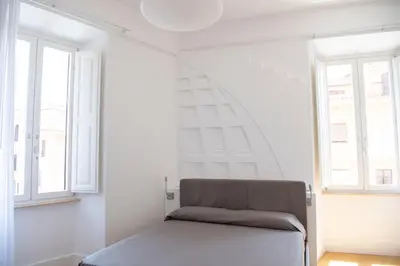 a bed in a white room with two windows at Rome in Rome in Rome