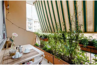 a balcony with a table and a window with plants at Eco B&B Marela in Rome