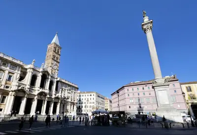 a large building with a clock tower and a pole at BQ House Colosseo Luxury Rooms in Rome