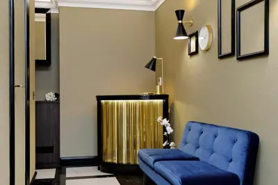 a living room with a blue couch and a gold radiator at BQ House Colosseo Luxury Rooms in Rome