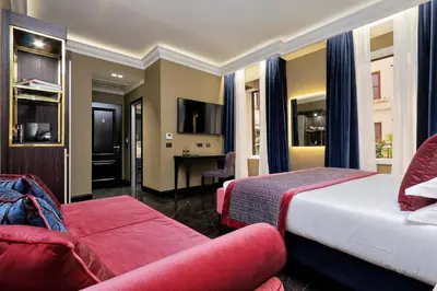 a hotel room with a bed and a couch at BQ House Colosseo Luxury Rooms in Rome