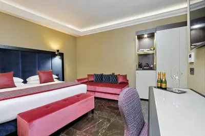 a hotel room with a bed and a couch at BQ House Colosseo Luxury Rooms in Rome