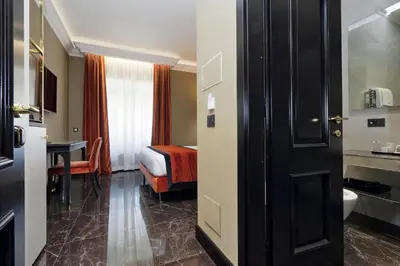 a hotel room with a bed and a bathroom at BQ House Colosseo Luxury Rooms in Rome